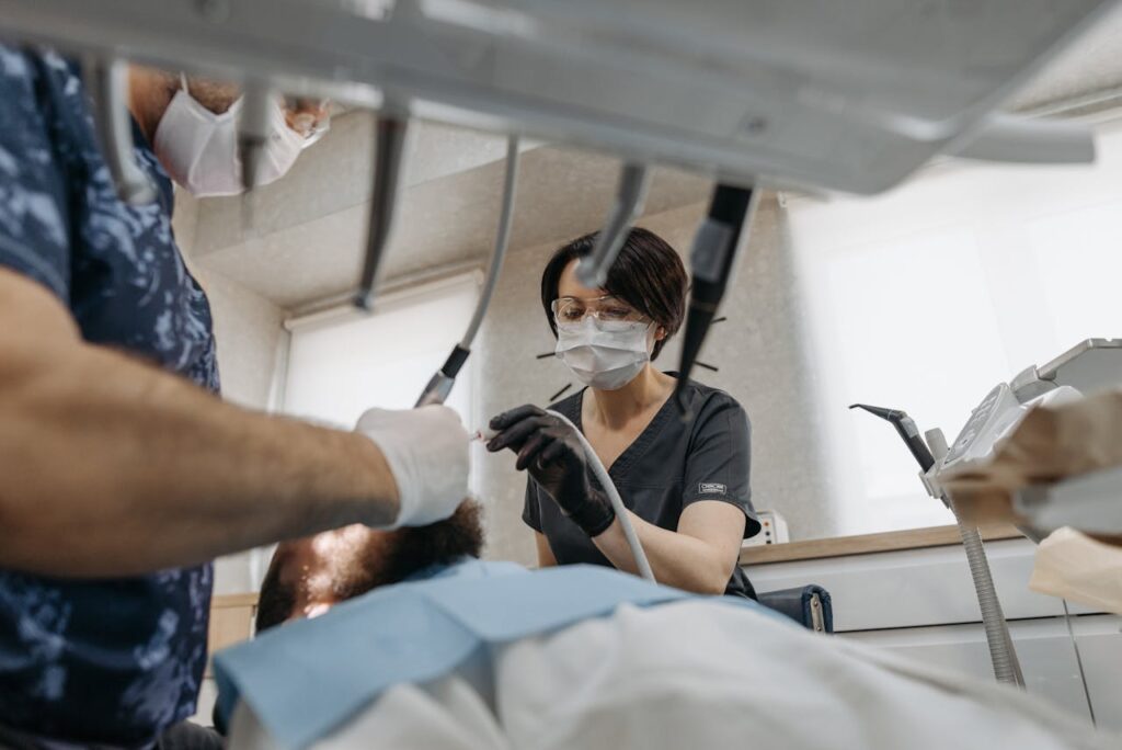 dentist fixing a patients toothache with dental nurse dentist fixing a patients toothache with dental nurse