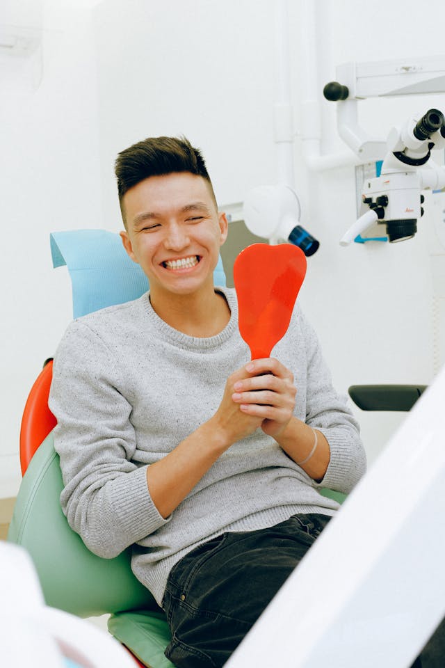man smiling looking at dental fillings in mirror man smiling looking at dental fillings in mirror