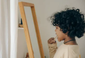child brushing teeth in mirror