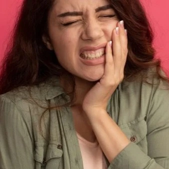 Woman Holding Side Of Face With Cracked Tooth Thumbnail