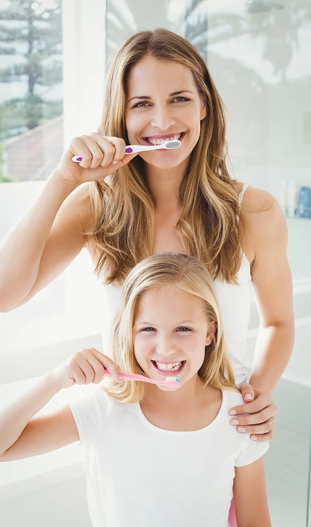 mother and daughter brushing teeth together