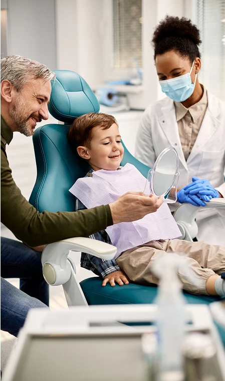 father son and dentist smiling