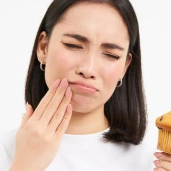 Woman With Sensitive Teeth Holding Cupcake Thumbnail