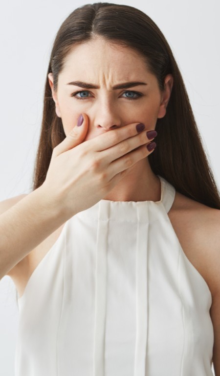 Displeased Young Brunette Girl Covering Mouth With Hand White Backround (medium)